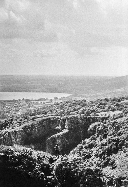 Photographer standing on a precarious outcrop, Cheddar Gorge